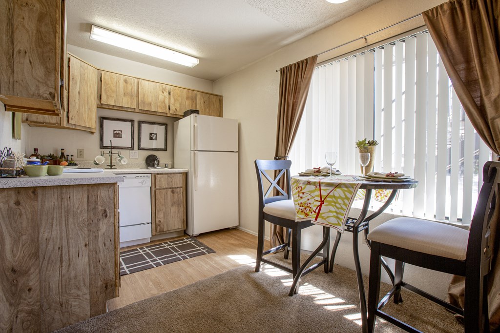 a kitchen and dining area with a table and chairs and a refrigerator