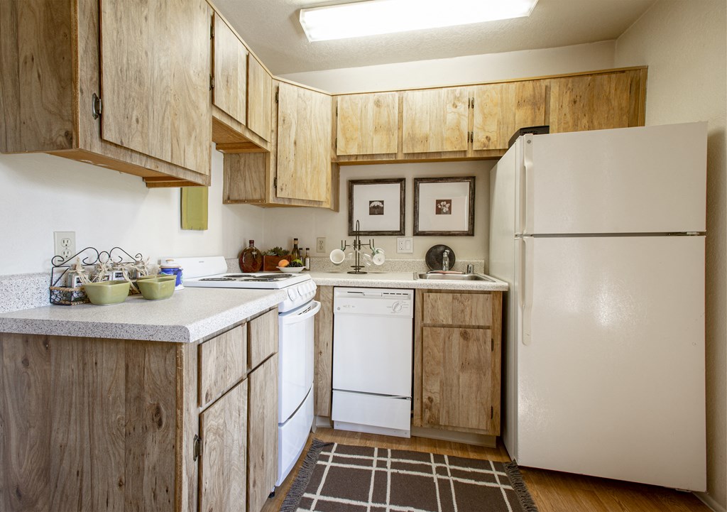 a kitchen with white appliances and wooden cabinets
