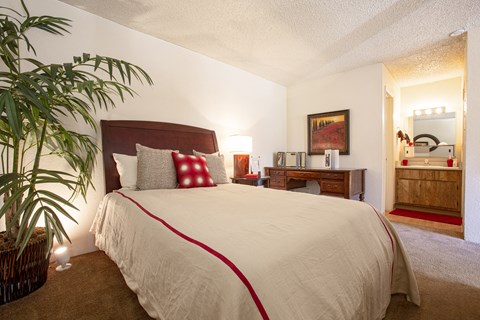 a bedroom with a large bed and a potted plant