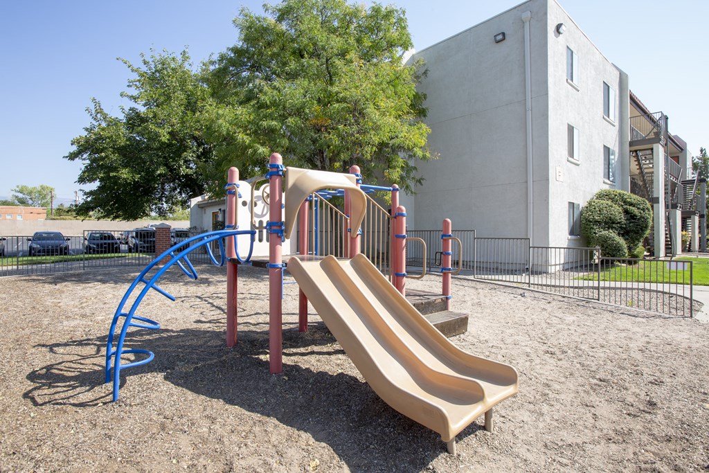 a playground with a slide in front of a building