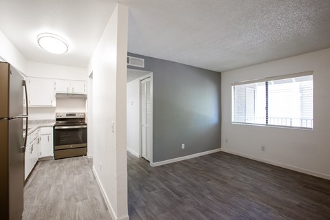 A kitchen with a refrigerator, oven, and cabinets.