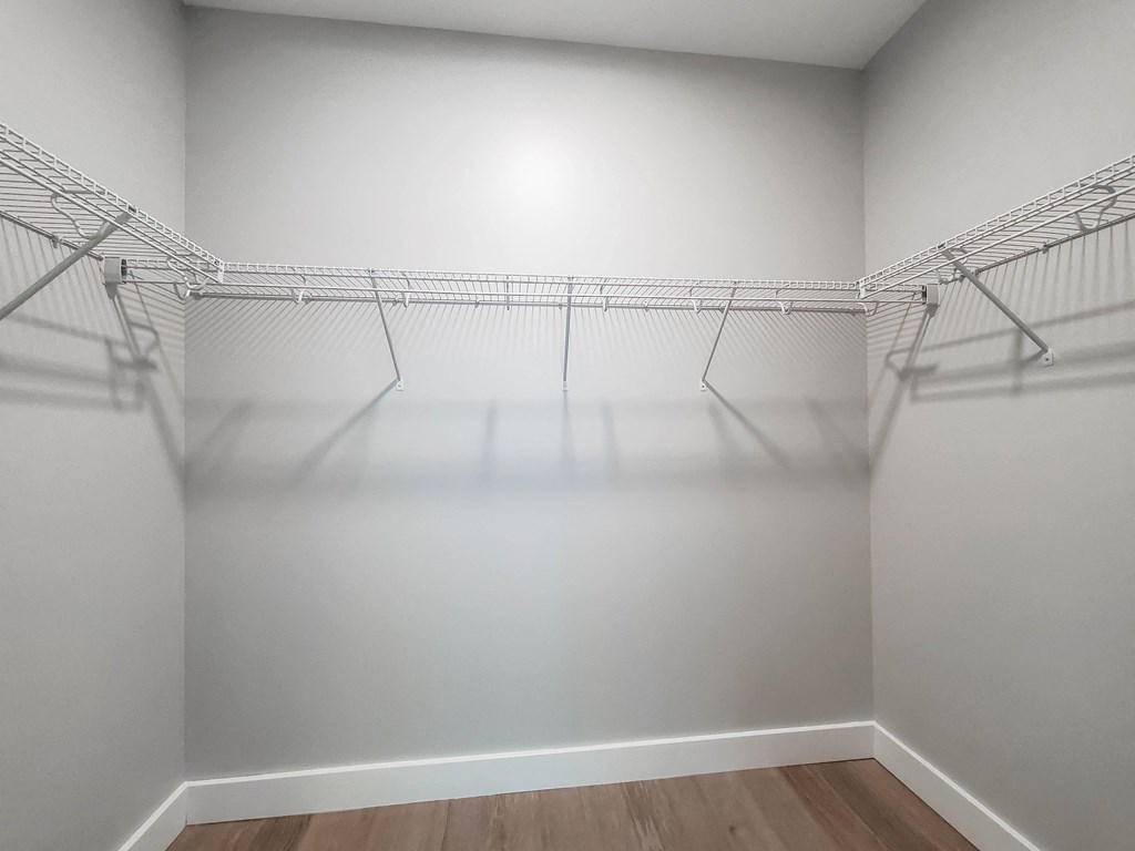 Empty wire shelving in a white room.