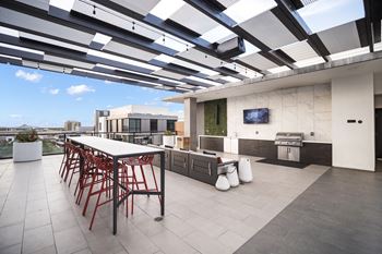 A patio with a table and chairs is covered by a roof.