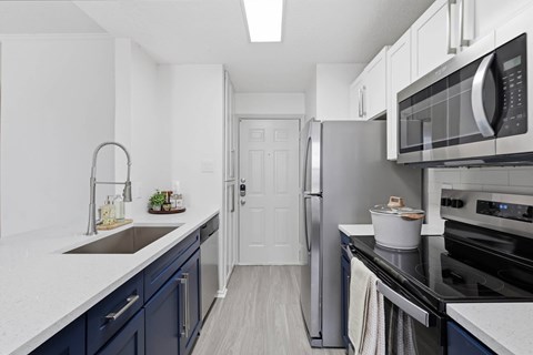 A kitchen with a white counter top and a sink.