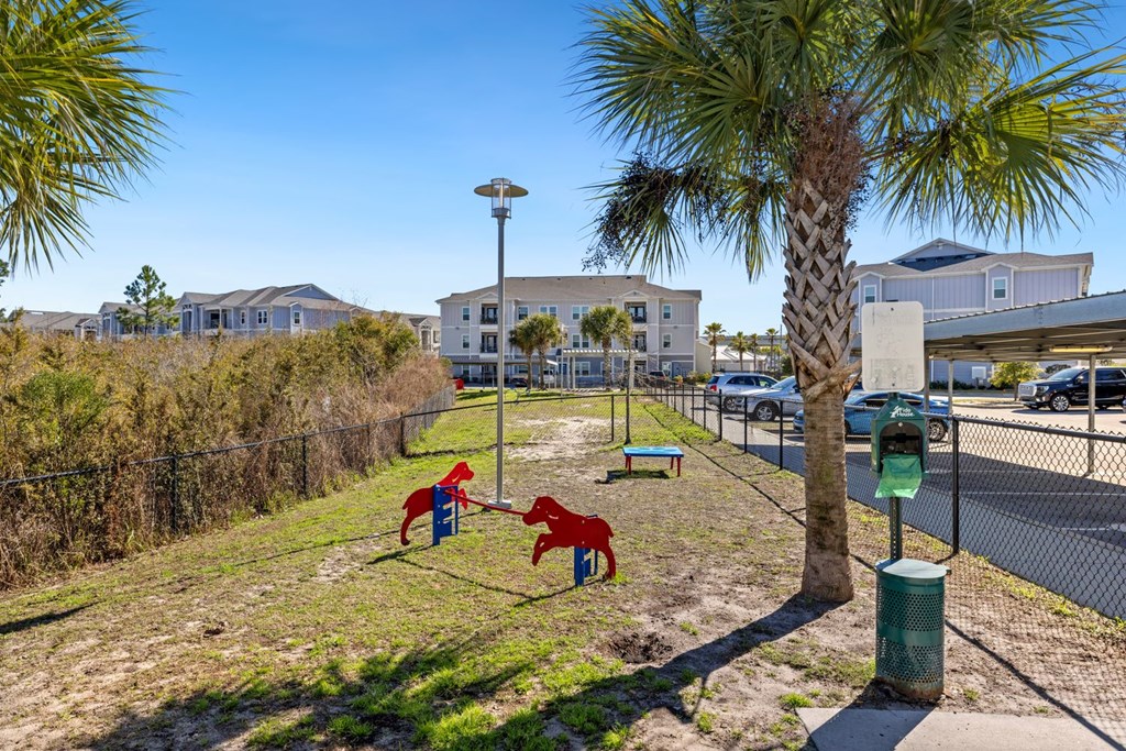 A playground with a swing set and a palm tree in the foreground.