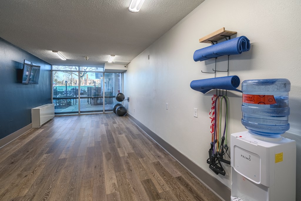 a workout room with water bottles and a water dispenser on the wall and a