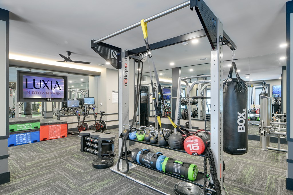 A gym with a boxing bag hanging from the ceiling.