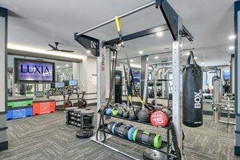 A gym with a boxing bag hanging from the ceiling.