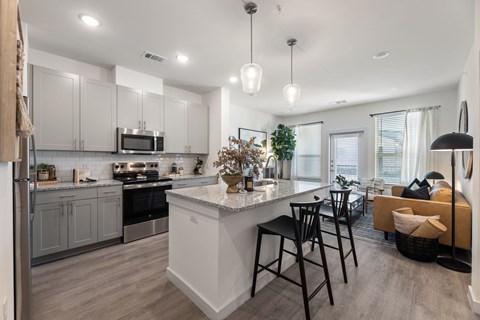 A modern kitchen with a large island and bar stools.