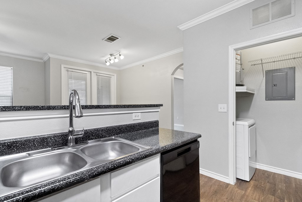 a kitchen with granite counter tops and a stainless steel sink