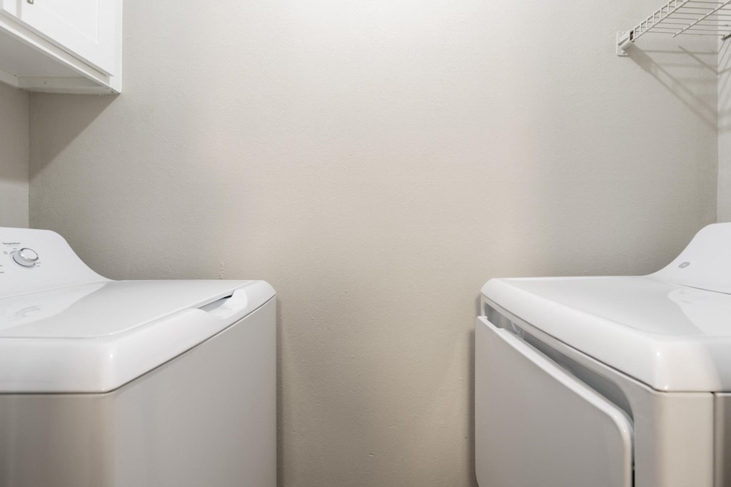 a white washer and dryer in a laundry room with two white washes