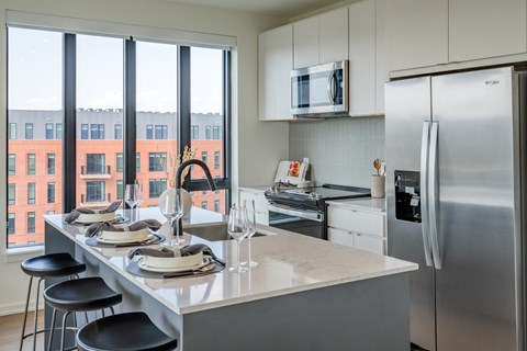 A modern kitchen with a dining table set for two.