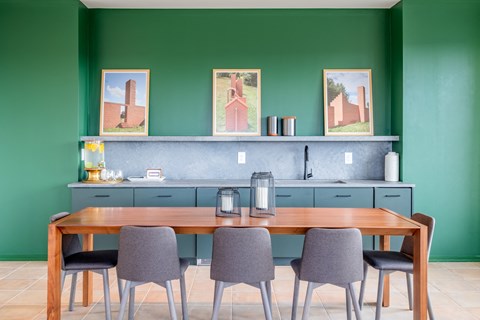 a dining room with green walls and a table with chairs