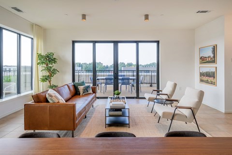 a living room with a couch and chairs and a balcony