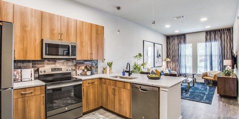 A modern kitchen with wooden cabinets and stainless steel appliances.