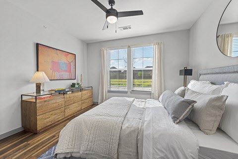 a bedroom with a large bed and a ceiling fan