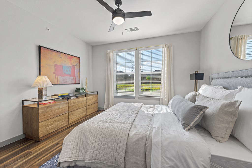 a bedroom with a large bed and a ceiling fan