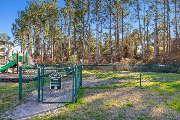 a playground with a gate and a slide in a park