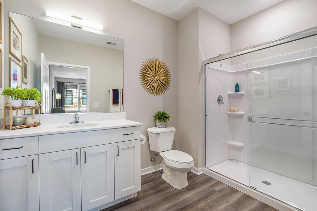 A white bathroom with a toilet, sink, and shower.