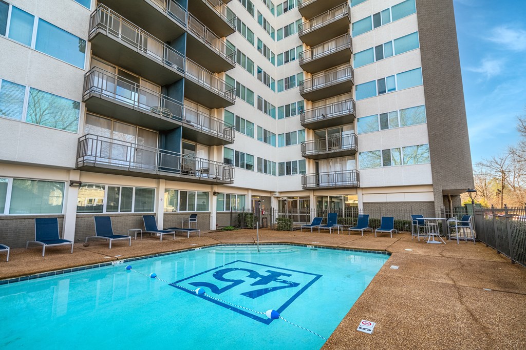 an apartment building with a large swimming pool in front of it