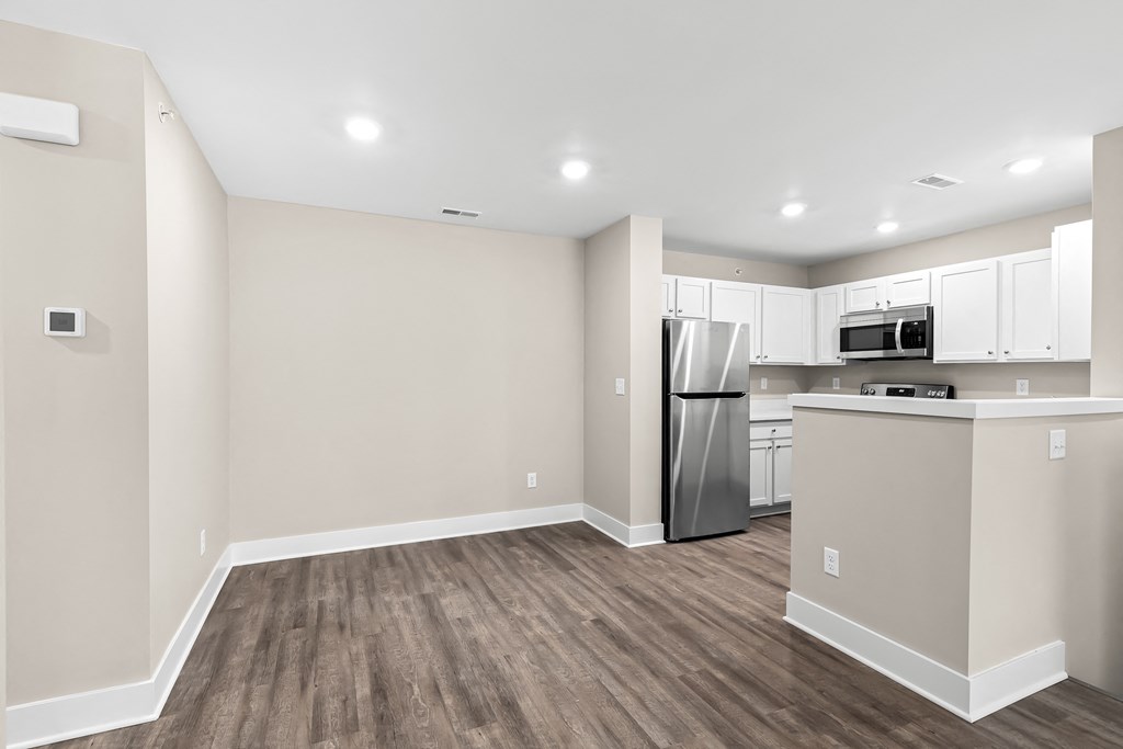 a kitchen with white cabinets and a stainless steel refrigerator