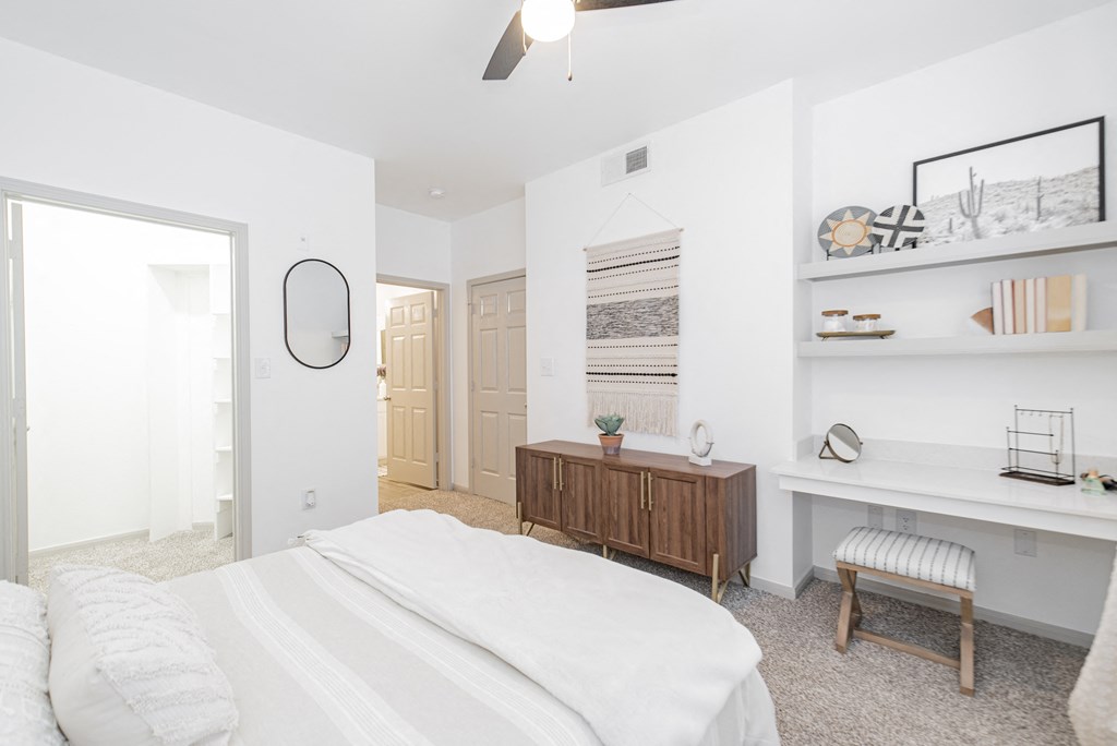 a bedroom with a white bed and a wooden dresser