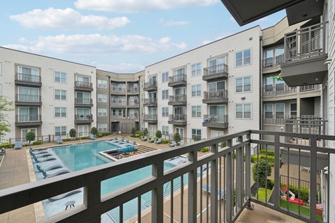 A view of a pool and apartment buildings from a balcony.