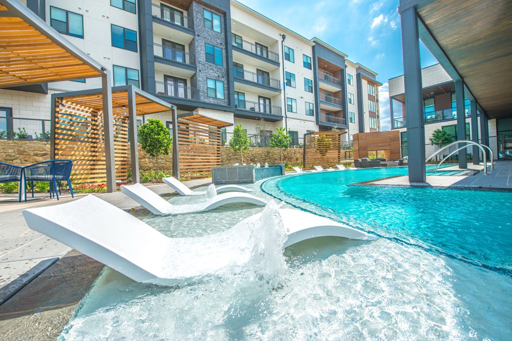 a swimming pool with an apartment building in the background