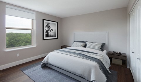 A bedroom with a large bed and a picture on the wall.