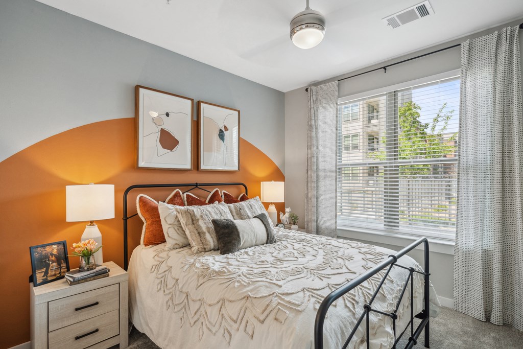 an orange accent wall in a bedroom with a bed