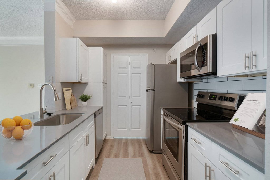 a kitchen with stainless steel appliances and white cabinets
