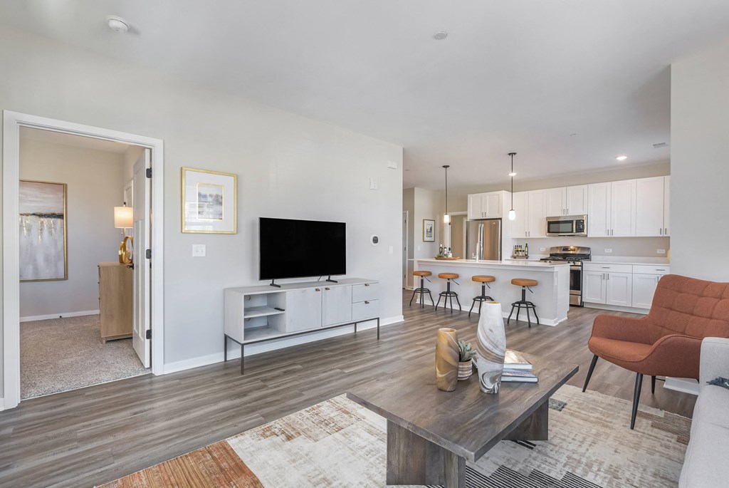 A modern living room with a wooden floor and a large flat screen TV.