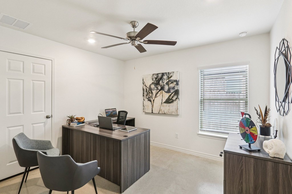A room with a desk and chairs.