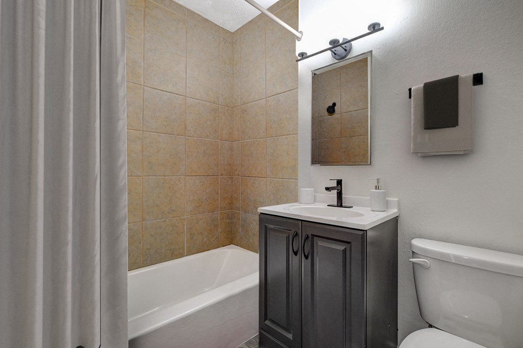 a bathroom with a shower and a sink and a toilet