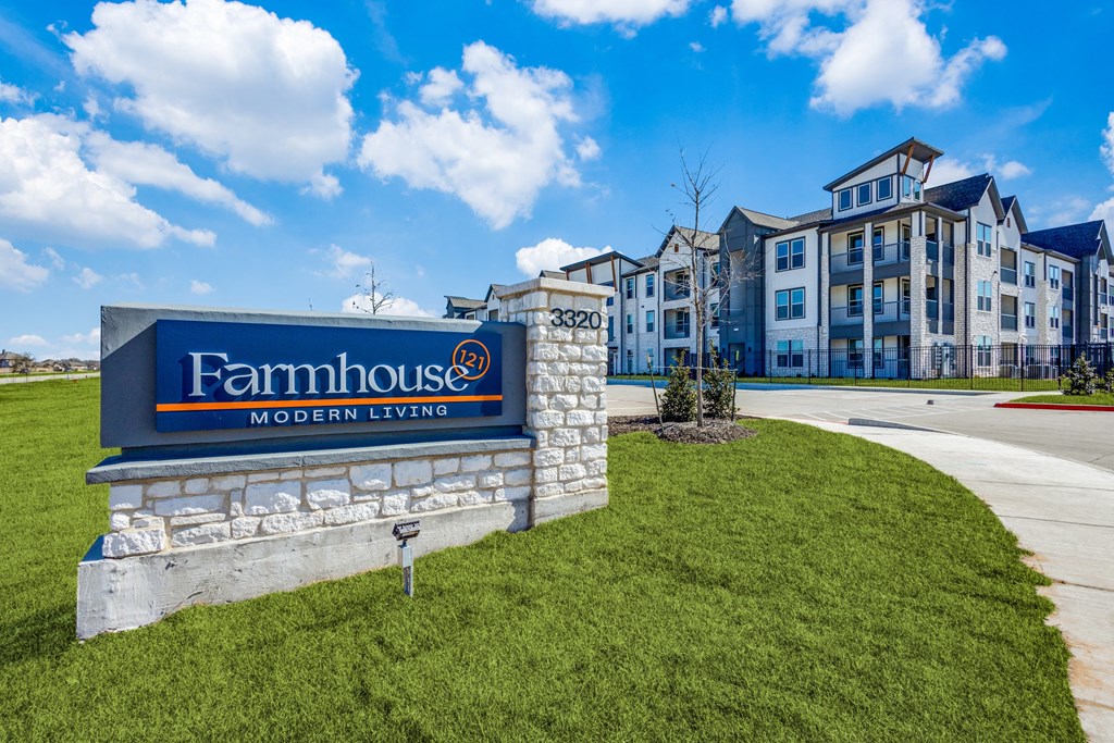 an apartment building with a sign for farmhouse modern living on top of a hill