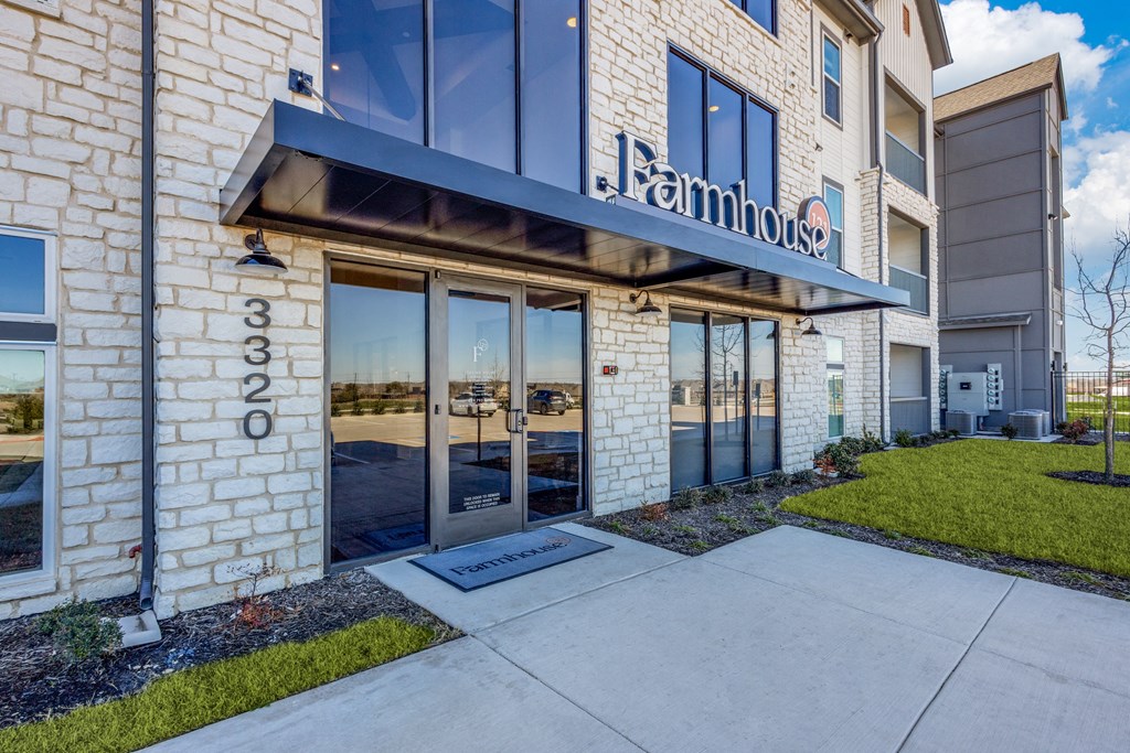 a building with glass doors and a sidewalk in front of it
