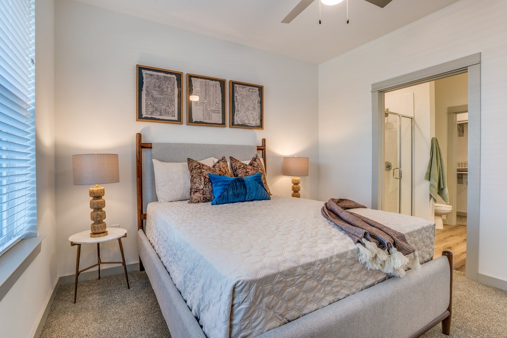 A bedroom with a large bed and a ceiling fan.