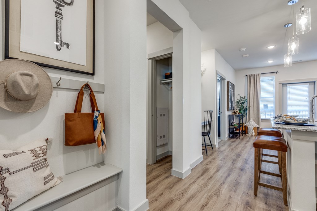 a living room with a hat and a purse on a wall and a dining room