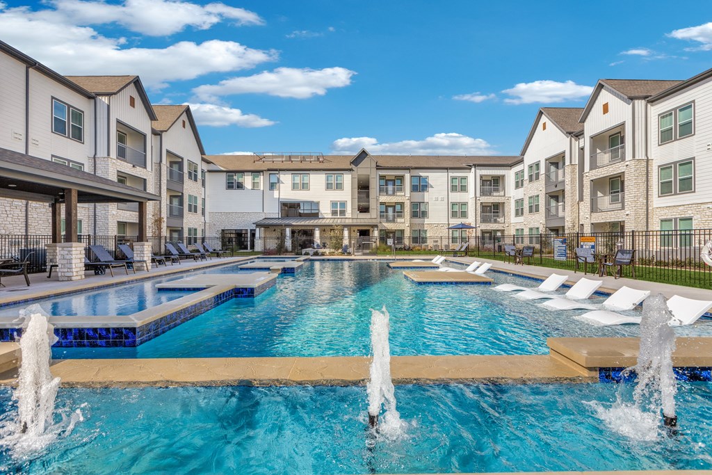 an apartment building with a pool and water fountains