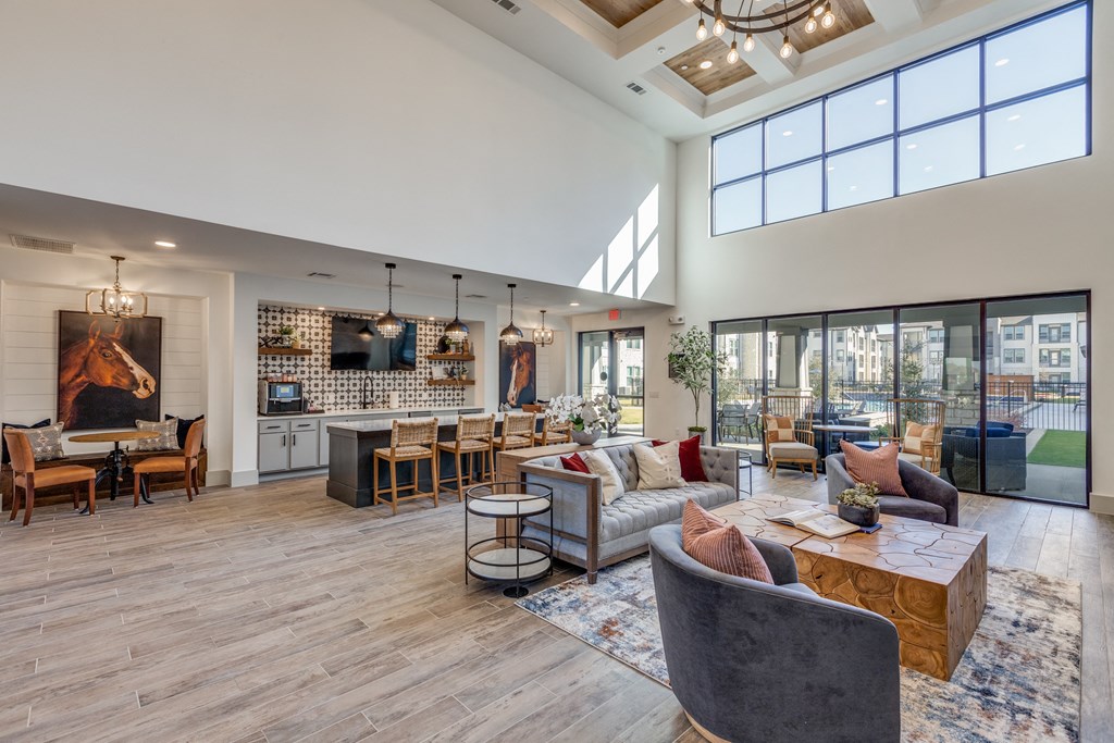 a spacious living room with couches and chairs and a kitchen with a large window