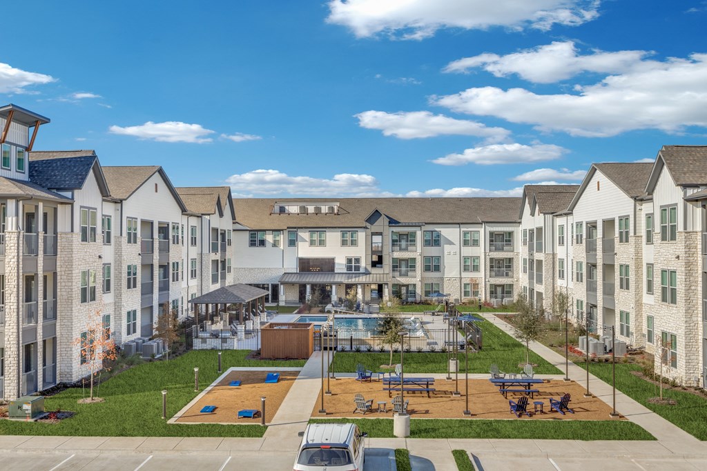 a large apartment building with a basketball court and a pool
