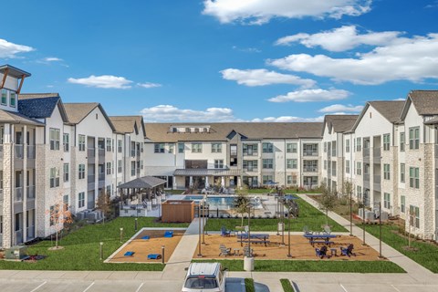 a large apartment building with a basketball court and a pool