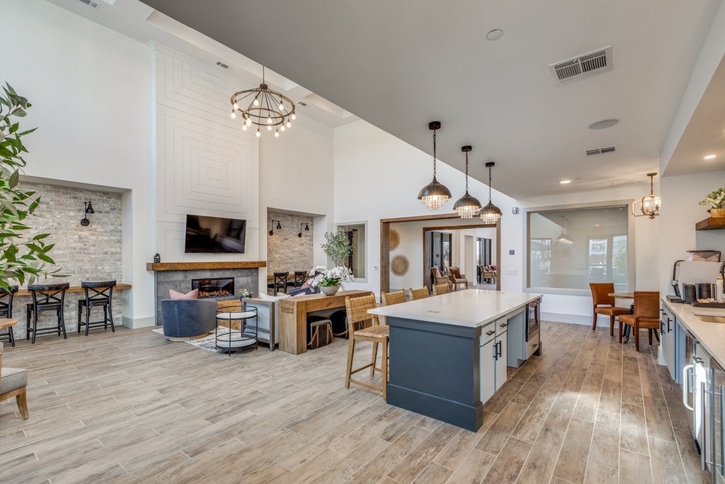 a living room with a fireplace and a kitchen with a blue island