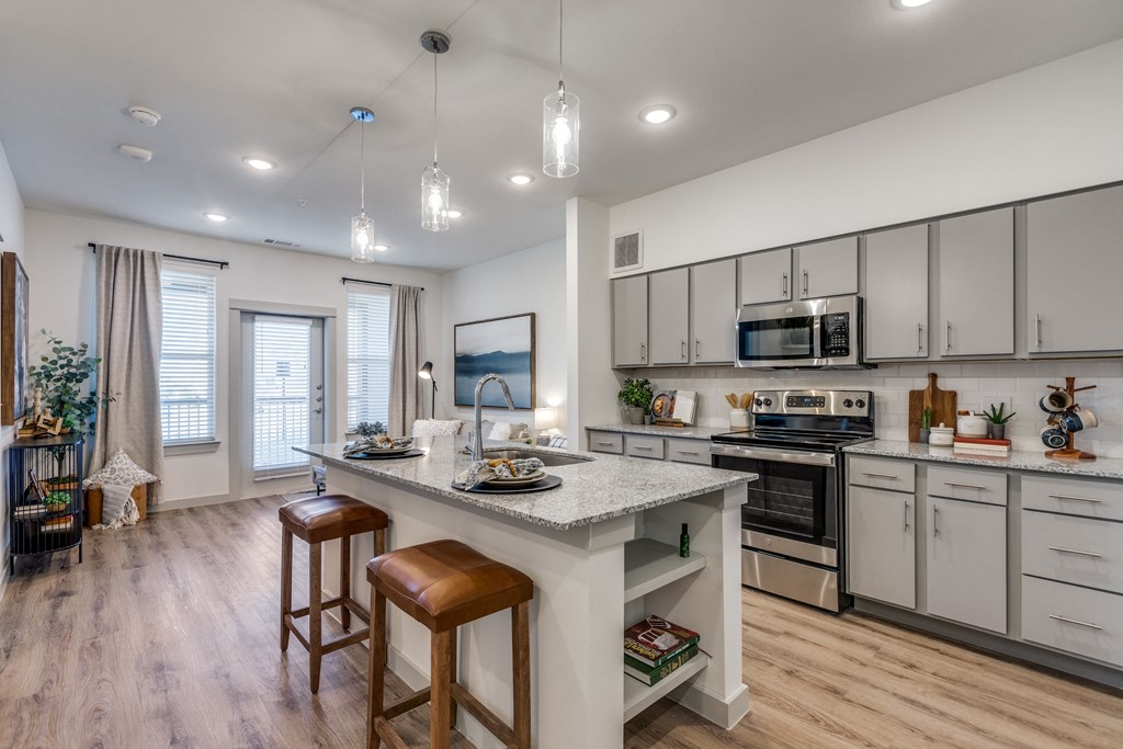 an open kitchen with a large island with two stools