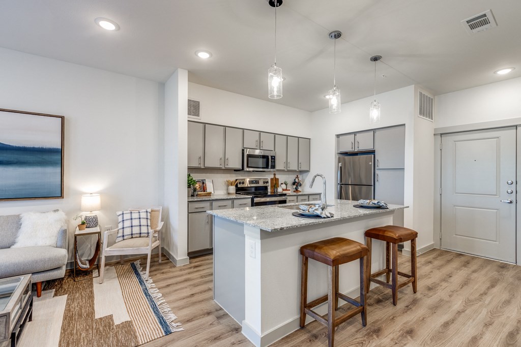 a kitchen and living room with an island and stools