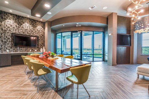 A modern dining room with a long table and yellow chairs.