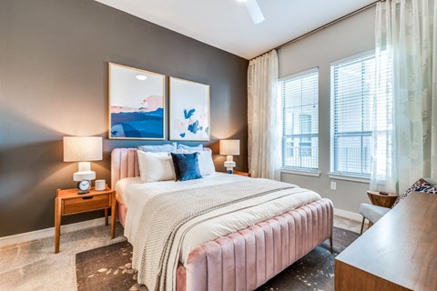 A bedroom with a large bed and a painting on the wall.