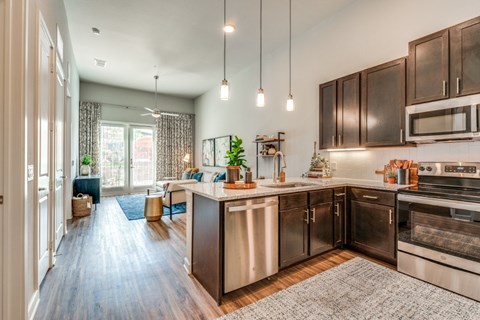 A modern kitchen with dark wood cabinets and stainless steel appliances.