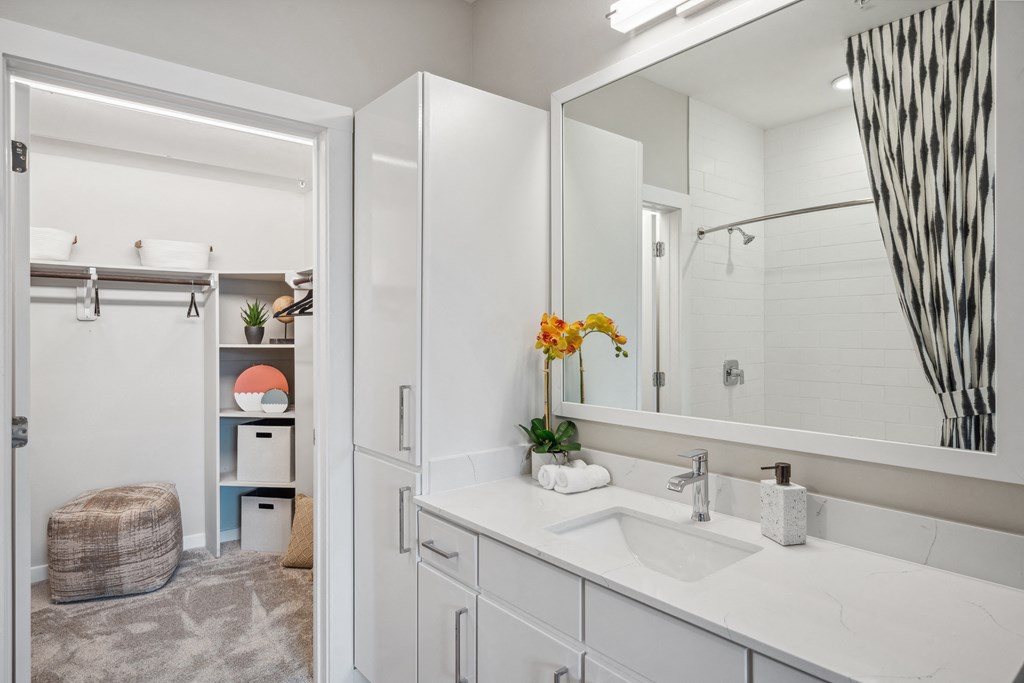 a white bathroom with a large mirror and a sink