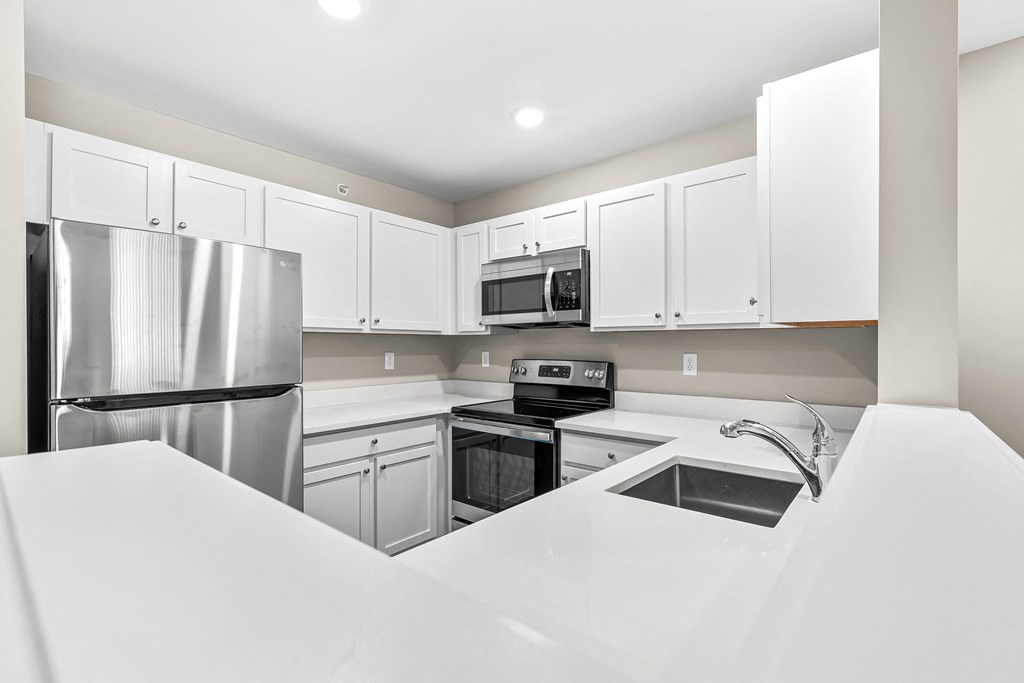 a kitchen with white cabinets and a stainless steel refrigerator